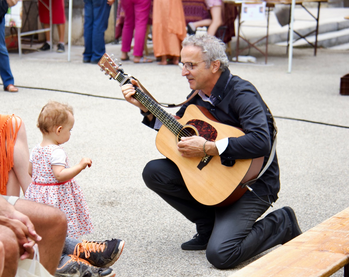 Young man with dark hair and beard, brown eyes, blue t-shirt
